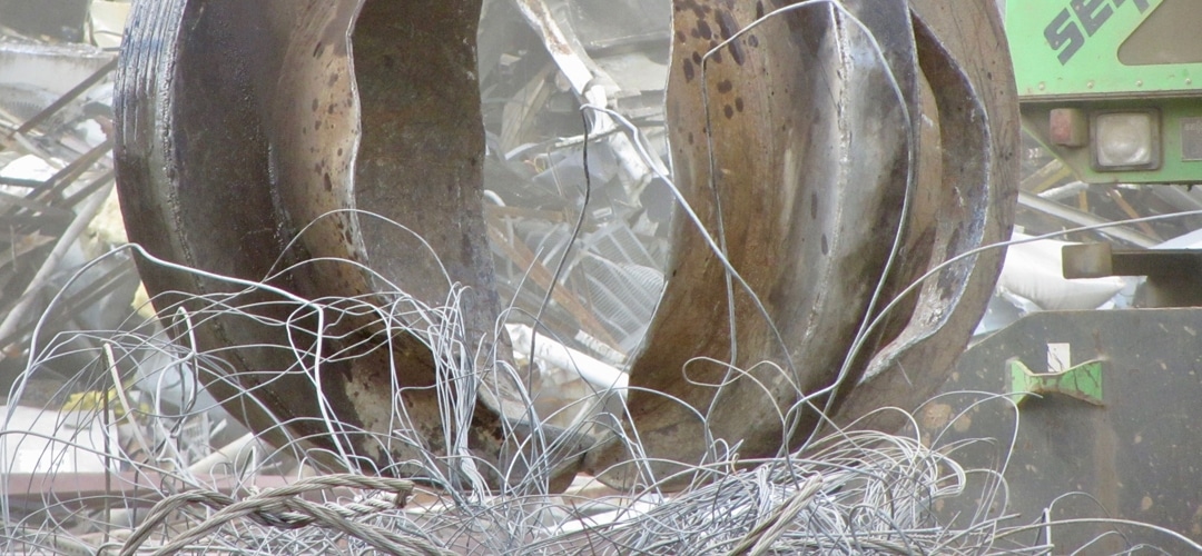 A grapple claw picking up scrap wire